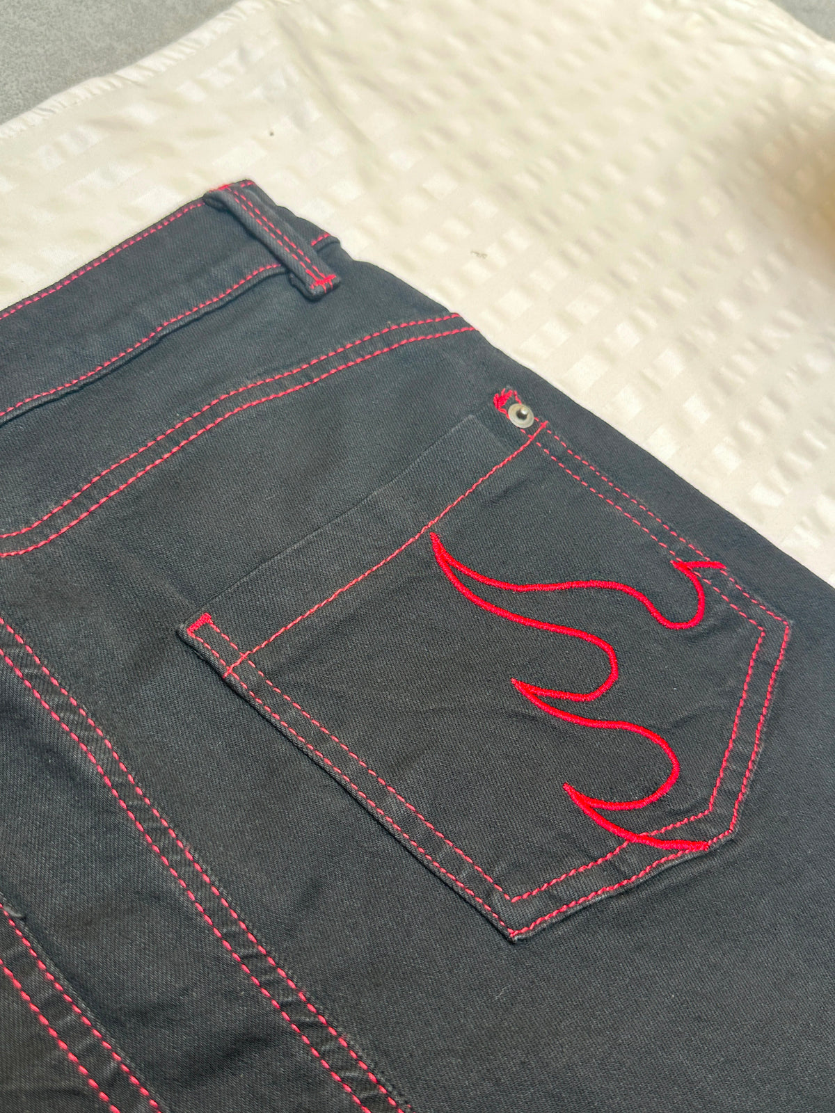 High-Waisted Black Flare Jeans with Red Flame Embroidered Hem & Contrast Stitching