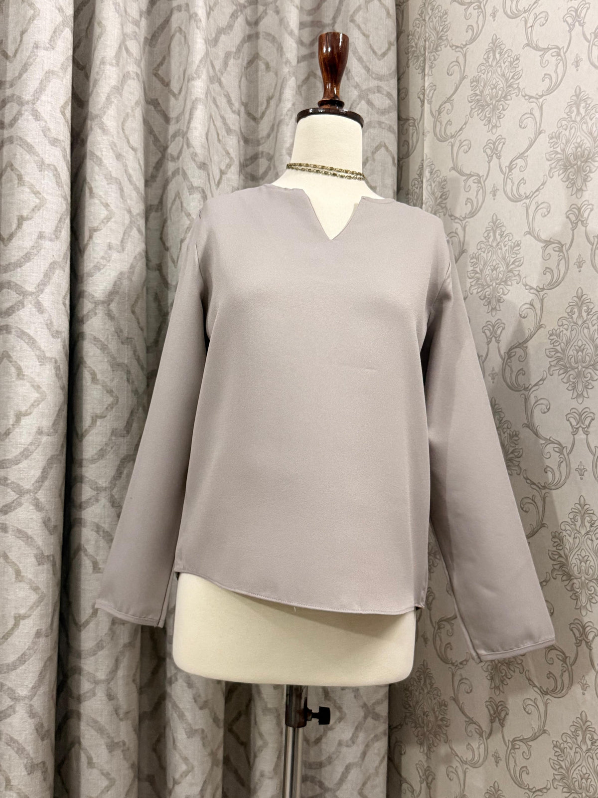 Minimalist Taupe Split-Neck Blouse with Curved Hem & Long Sleeves